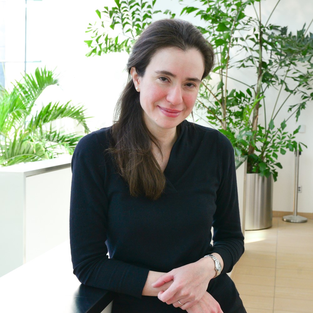 A portrait of Myriam Heiman with plants in the background